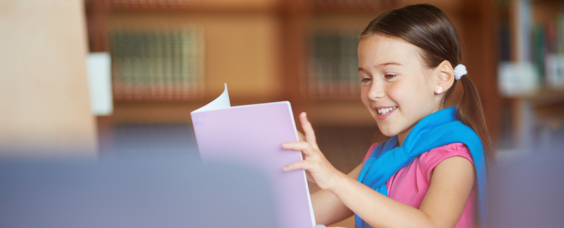 Three elementary students reading together